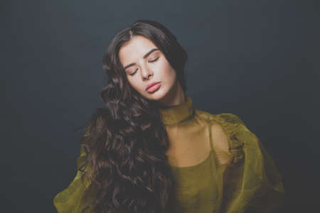 Beautiful hair model woman brunette with long curly hairstyle on black background