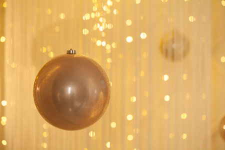 Golden decoration bauble on abstract bokeh glitter light backgroundの写真素材