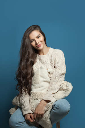 Healthy young woman with white pillow on blue background