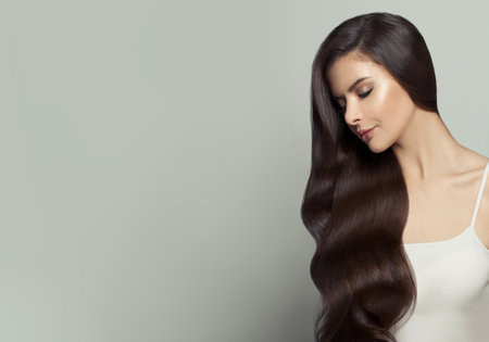 Beautiful woman with long healthy hair on white background. Haircare and facial treatment conceptの写真素材