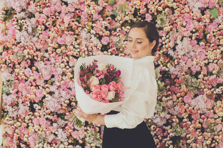 Lovely woman with flowers on pink roses floral blossom backgroundの写真素材