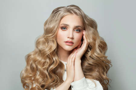 Pretty face. Cute blonde woman with long healthy hair on white backgroundの写真素材