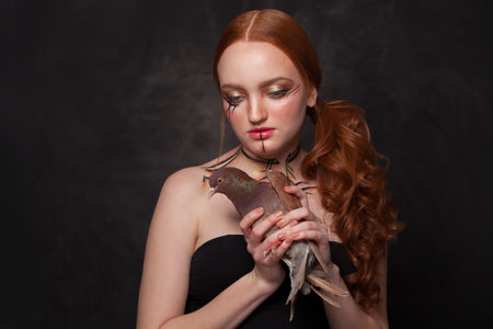 Beautiful woman with Halloween makeup on black background. Studio portrait.の写真素材