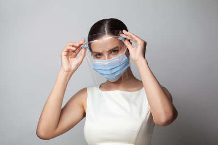 Portrait of perfect young woman in face shields and protective mask. Covid-19 protection concept