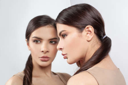 Closeup upset young woman with worried stressed face expression and mirror. Stress, obsessive...
