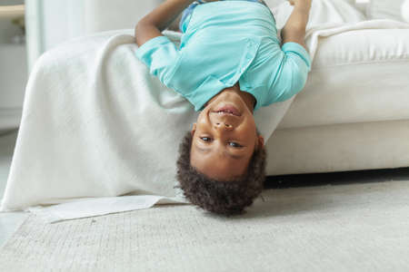 Portrait of happy little boy wearing blue t-shirt smiling and looking at cameraの写真素材