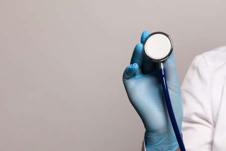 Stethoscope in doctor hand on grey backgroundの写真素材