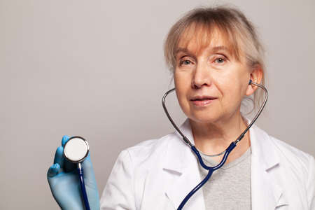 Doctor using stethoscope on grey background