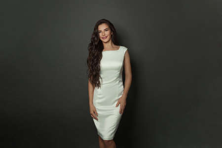 Brunette female model with long healthy shiny wavy hairstyle. Beautiful young woman with curly hair...
