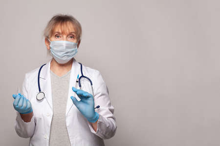 Doctor, nurse or scientist in blue gloves holding syringe and ampoule. Vaccination, medicine and treatment concept.の写真素材