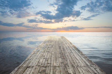 Lake at Sunset. Wooden jetty and sky cloudsの写真素材