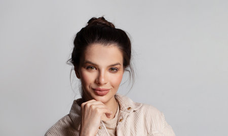 Close up portrait of confident friendly woman on grey background.