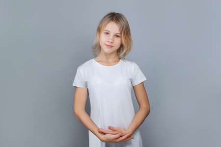 Cheerful teen girl 10-12 years old posing against a gray wall.の写真素材