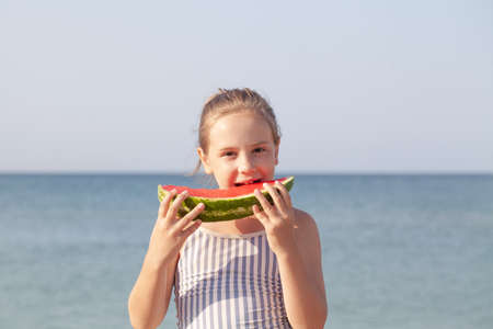 Little girl with bid watermelon segment, summer portraitの写真素材