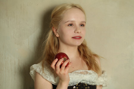 Portrait of young blonde woman with red apple close upの写真素材