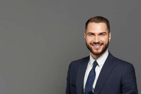 Handsome happy businessman smiling, indoor studio portraitの写真素材