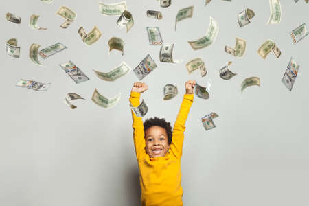 Cute little child under dollar rain