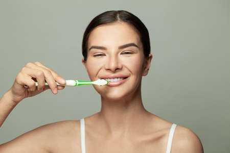 Close-up of a young woman is brushing her teeth. Dental health care clinic.の写真素材