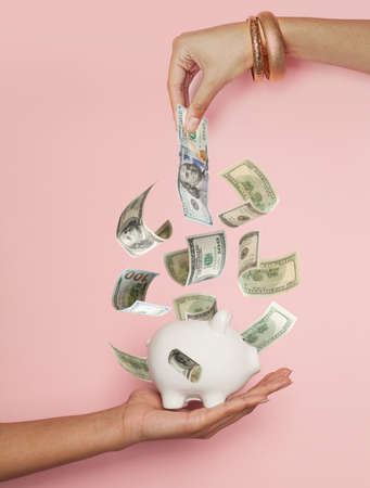 American dollar money in glamorous female hand on pink background