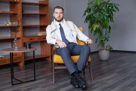 Portrait of successful young man in white shirt and tie indoor