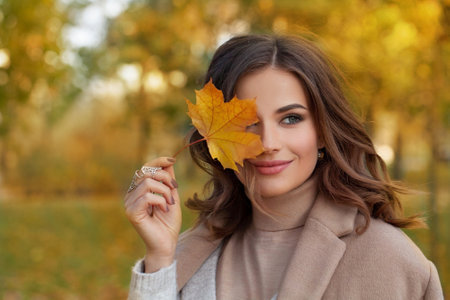 Outdoor atmospheric lifestyle portrait of young beautiful lady. Warm autumnの写真素材
