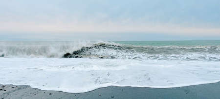 Panoramic seascape. Beautiful wave of the sea on the black sandy beach