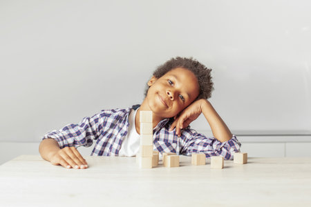 Happy young boy playing and looking at camera at homeの写真素材