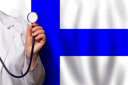 Finnish medical worker's hand with stethoscope on flag of Finland backgroundの写真素材