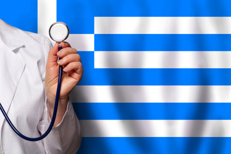 Greek medical worker's hand with stethoscope on flag of Greece backgroundの写真素材