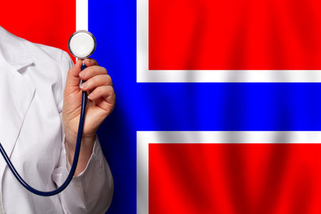 Norwegian medical worker's hand with stethoscope on flag of Norway backgroundの写真素材