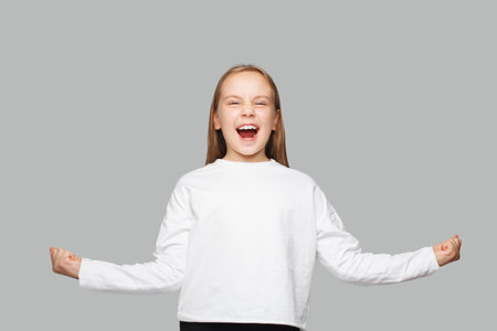 Happy excited surprised child kid schoolgirl having fun and posing on white background, closeup studio portrait. Childhood conceptの写真素材