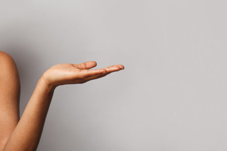 Empty female hand. Open palm hand on gray banner backgroundの写真素材