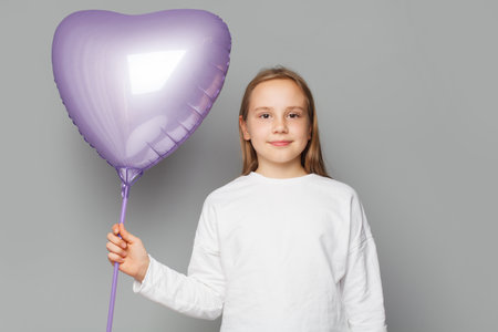 Happy cute child with balloon on gray studio backgroundの写真素材