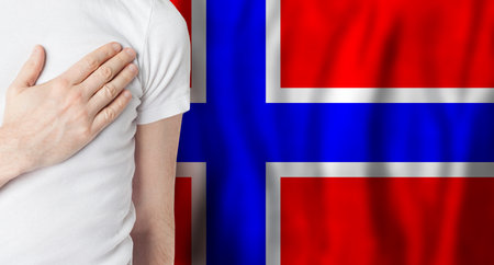 Norwegian person with hand on heart on the background of Norway flag. Patriotism, country, national pride conceptの写真素材