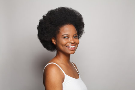 Portrait of healthy happy female model woman brunette with clean fresh dark skin on gray background. Skincare and facial treatment conceptの写真素材