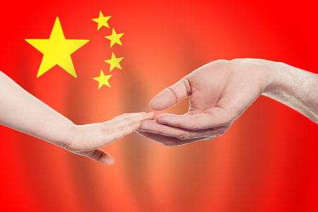 Chinese baby and parent hands on the background of flag of China Help, aid, support, charity conceptの写真素材