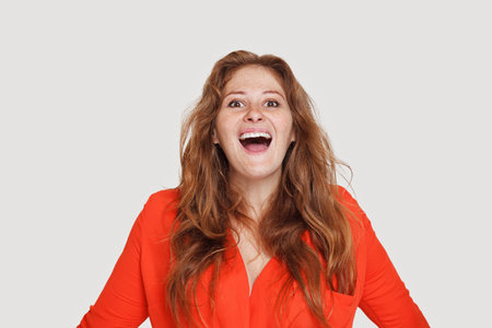 Happy excited woman redhead female laughing on whiteの写真素材