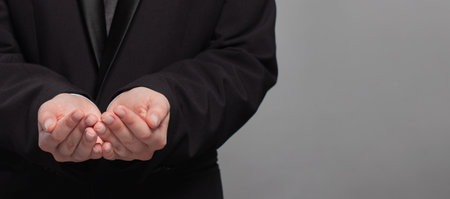 Businessman hands on gray background. Communication, technology, IoT, internet, global, network, futuristic conceptの写真素材