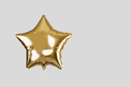 golden balloon on light gray backgroundの写真素材
