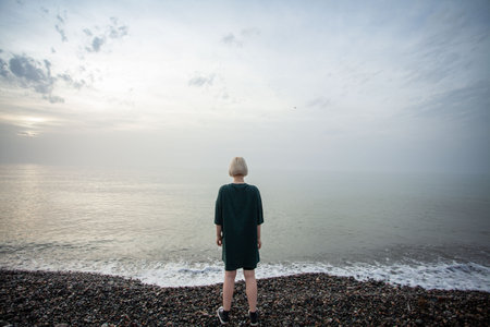Young adult woman looking at sea and sky outdoorsの写真素材