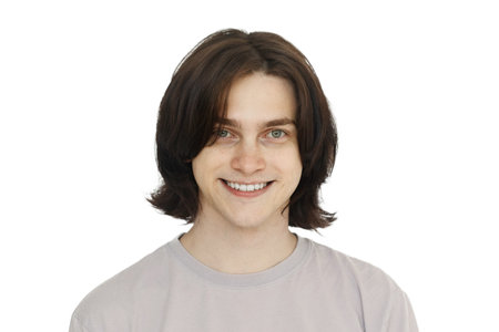 Happy smiling young man with long brown hair and friendly smile portrait