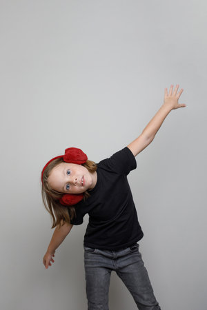 Happy kid girl standing on gray backgroundの写真素材