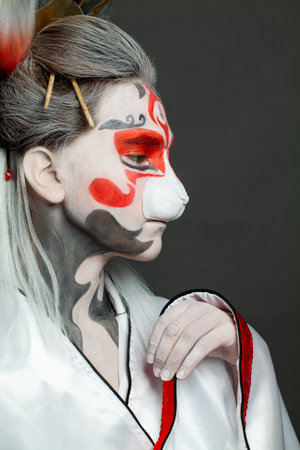 Halloween makeup. Cute woman with make-up and costume in Asian style, beautiful face closeupの写真素材