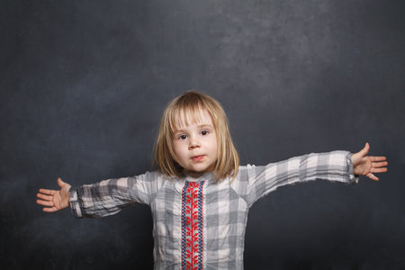 Portrait of a pretty little baby girl having fun on blackboard backgroundの写真素材