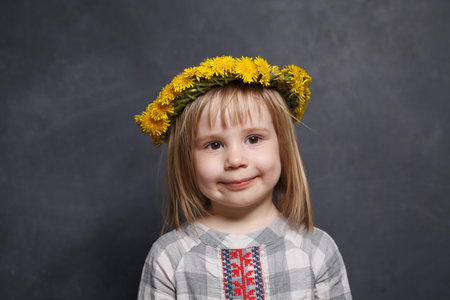 Adorable little girl with yellow dandelion flowers portraitの写真素材