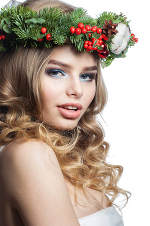 Nice healthy young woman with party makeup, long blonde curly hairdo and Christmas decor isolated on white background. Christmas beautyの写真素材