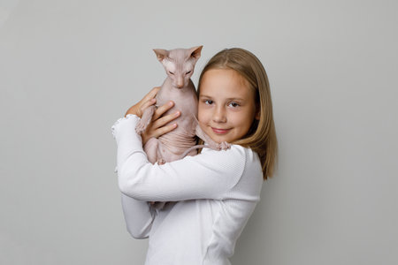 Adorable child girl holding cat on white background, studio portraitの写真素材
