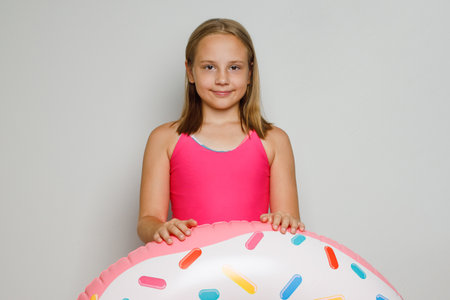 Adorable happy child girl with inflatable ring swimming float closeup. Summer, vacation and leisure activity conceptの写真素材