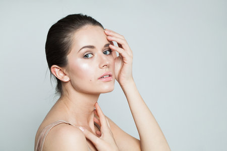 Healthy fashion beauty model brunette with clear skin and dark hair. Beautiful young female face closeup portraitの写真素材