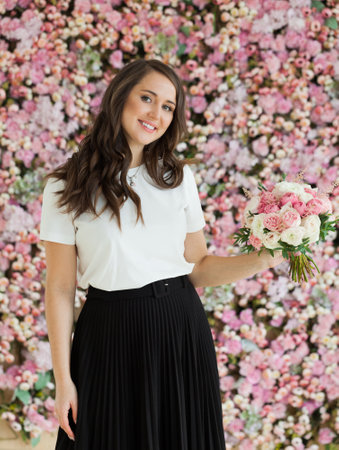 Joyful lady with flowers. Happy brunette woman indoor portraitの写真素材